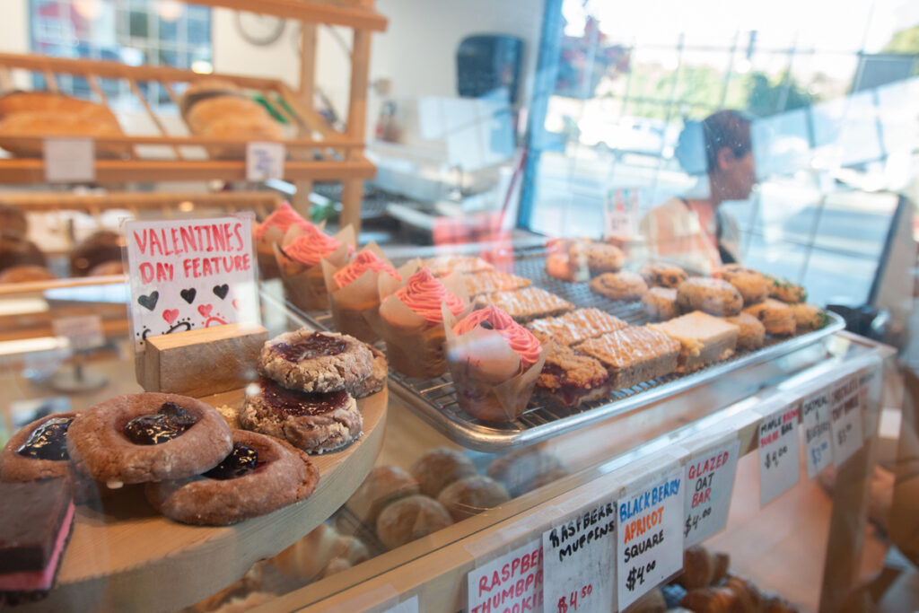 A closeup of the bakery case shows thumbprint cookies, raspberry muffins, and more.