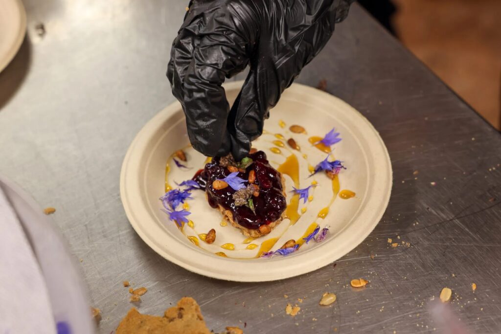 A student from Siletz Valley Schools’ culinary program adds the final touches to a cassava flour cracker dessert for Indigenous Food Summit attendees to try at Portland State University on September 10, 2026. (Photo by Nika Bartoo-Smith, Underscore Native News / ICT)