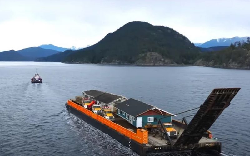 A pre-fab house is on a boat.